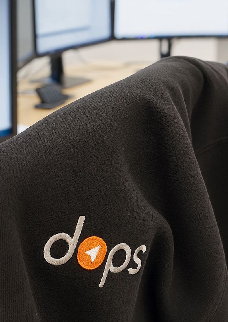 DOPS-genser med logo foran utviklerskjermer